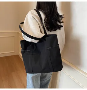 Modell mit schwarzer Canvas-Tasche mit Seitentasche in minimalistischem Interieur