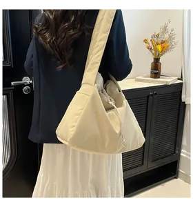 Detail of a beige puffy tote bag with soft fabric texture and side drawstring feature