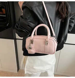 Detailed view of pink patent leather pillow bag with heart charm and silver hardware