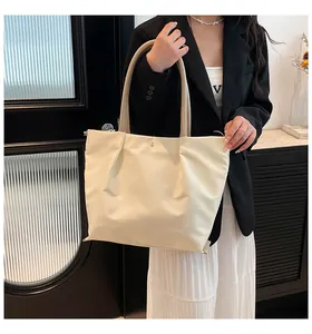 Detail of soft pleated synthetic leather tote bag with magnetic metal clasp and twin handles