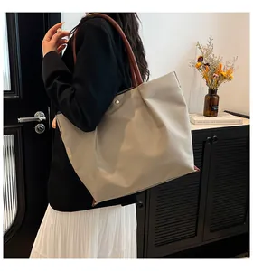 Detail showing high-capacity minimalist tote bag with smooth texture and side snap button