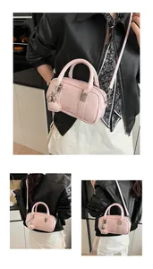 Detailed macro view of pink glossy pillow bag with double handles and heart charm accessory