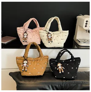 Quilted puff bucket bags in pink, beige, brown, and black with bow embroidery and dolls