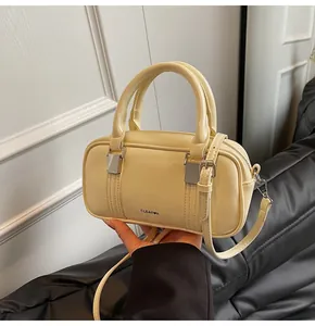 Detailed close-up of cream-colored pillow bag with Clear K logo and silver hardware