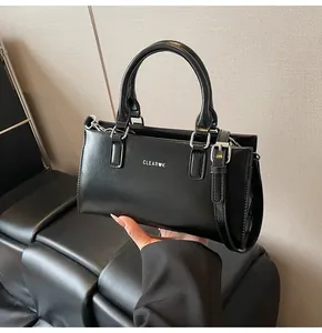 Detail der schwarzen Ledertasche mit weißem Clear-Heart-Logo und silbernen Metallteilen