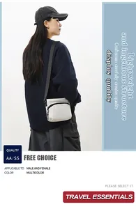 Detailed view of lightweight white nylon crossbody bag featuring black zippers and straps