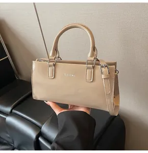 Detail der beigen Clear K Handtasche mit glatter Lederstruktur und verstellbarem Riemen