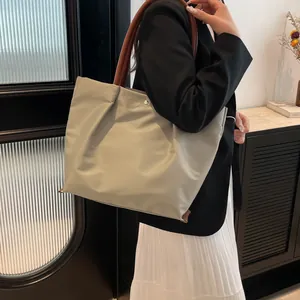 Waterproof nylon tote bag with brown leather handles and magnetic snap closure
