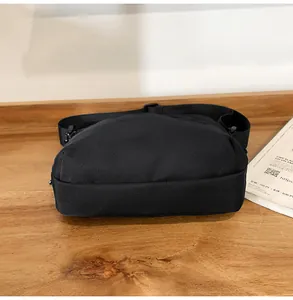Detailed bottom view of black nylon crossbody chest bag showing texture and stitching