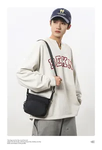 Detailed view of black nylon crossbody bag with dual zipper pockets and adjustable strap