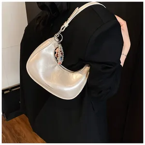 Detail of cream hobo bag showing pearl charm and Fashion & Bags text on oil-skin leather