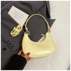 Detail of pale yellow baguette bag on grey blazer with detachable shoulder strap
