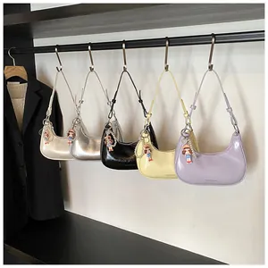 Detail view of colorful faux leather baguette bags with pearl girl charms in a boutique display