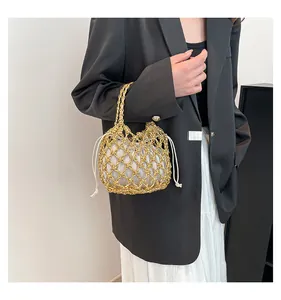 Detail der handgewebten goldenen Netztasche mit silbernem Kordelzugfutter an Model