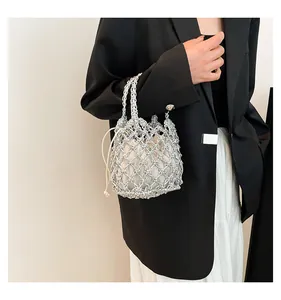 Silberne geflochtene Netztasche mit weißem Kordelzug-Innenbeutel von Model getragen