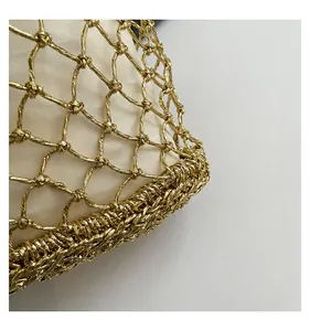 Nahaufnahme der goldenen Netzstruktur und des beigen Stofffutters dieser Strandtasche