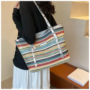 Detailed side view of large colorful woven straw tote bag with silver metallic straps