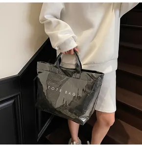 Glänzende schwarze Tragetasche mit weißem Text für einen schicken Look am Model