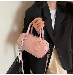 Detailed shot of pink textured leather bowling bag with embossed logo and silk scarf detail