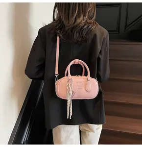 Pink bowling style handbag with adjustable shoulder strap and embossed UOR logo