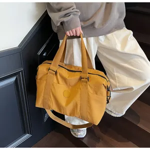 Close-up of yellow travel bag showing waterproof nylon texture and sturdy carry handles