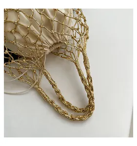 Detailansicht der gewebten goldenen Netztasche mit einem weißen Satin-Zugbeutel innen