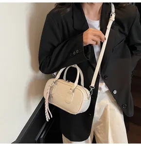 Detail of cream Boston bag with UOR UOR embossing and floral side pattern on crossbody strap