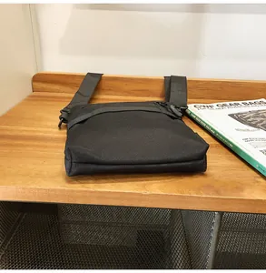 Detailed view of durable black nylon crossbody bag texture on a wooden surface