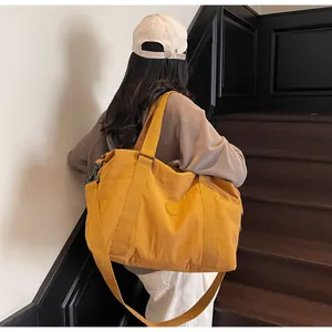Detailed view of the large yellow canvas travel bag with wide straps on stairs