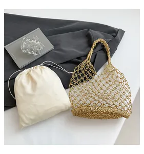 Detail der goldmetallischen gewebten Netztasche mit weißem Satin-Kordelzug-Innenbeutel