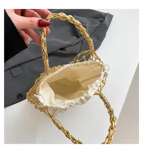 Detail der gold gewebten Netztasche mit cremefarbenem Kordelzugfutter und Spiralgriffen