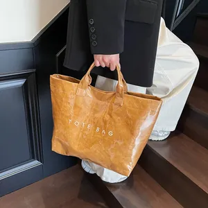 Braune Dupont-Papiertragetasche mit großem TOTE BAG-Aufdruck und glänzendem Obermaterial