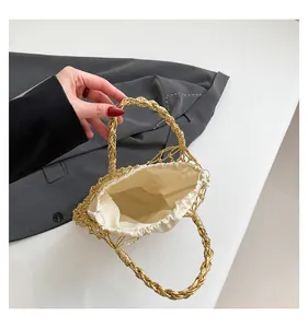 Detail der goldenen gewebten Tasche mit cremeweißem Kordelzugfutter und robusten Griffen