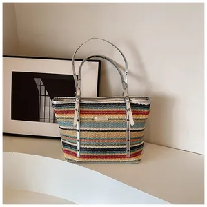 Detail of multi-color woven tote bag with silver adjustable metal eyelet straps