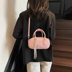 Pink retro bowling handbag with textured PU leather and tennis racket charm worn crossbody