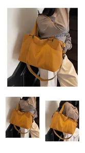 Detail of ginger yellow travel bag showing the handles, adjustable strap and side pockets