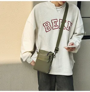 Detailed view of army green nylon crossbody bag with multi-zipper and adjustable strap