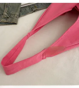 Detailed close-up of pink canvas tote strap with reinforced stitching and twill texture