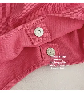 Detailed macro view of the silver magnetic metal buckle on a pink canvas tote bag