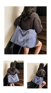 Detailed side view of light blue travel bag being carried over the shoulder on a staircase