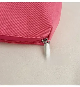 Detail of smooth silver metal zipper on durable hot pink canvas tote bag surface