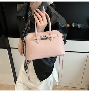 Dettaglio borsa a conchiglia rosa con texture a grana e fibbia in metallo argentato