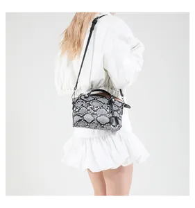 Modern python pattern handbag worn by a model with an adjustable shoulder strap