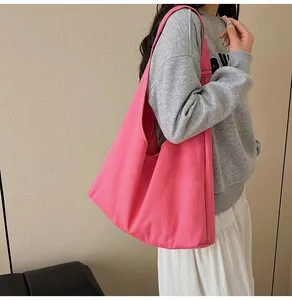 Detail view of large rose pink canvas tote bag on model showing size and wide shoulder strap