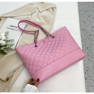 Detail view of pink quilted tote bag with chain strap on a beige blazer setting