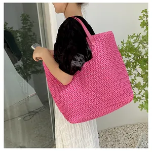 Close-up of bright pink woven tote bag showing detailed diamond texture and shoulder strap