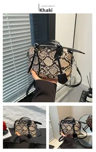 Detailed view of khaki snakeskin pattern handbag with black handles and silver hardware