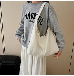 Large off-white canvas tote bag shown on a model for a casual and stylish daily look