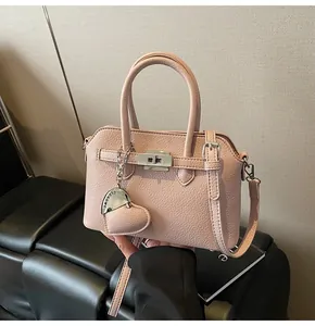 Borsa a conchiglia rosa in pelle grana con chiusura argento e ciondolo a cuore