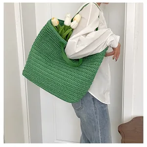 Detail of green woven tote bag showing large capacity with white tulips inside